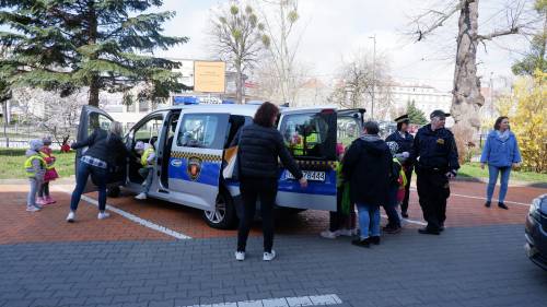 Przedszkolaki z Oddziału Przedszkolnego Szkoły Podstawowej nr 4 w Pruszczu Gdańskim oglądają samochód Straży Miejskiej Widok na lewy tył samochodu.